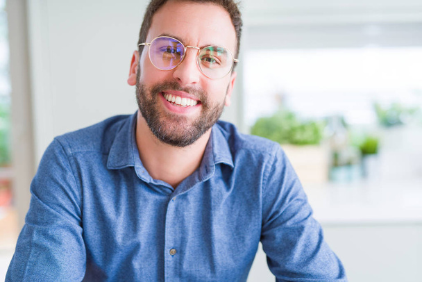 Handsome man wearing glasses and smiling relaxed at camera - Photo, Image