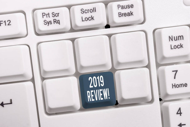 Conceptual hand writing showing 2019 Review. Business photo showcasing remembering past year events main actions or good shows White pc keyboard with note paper above the white background. - Photo, Image