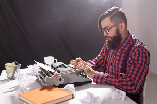 mensen, schrijver en hipster concept - jonge stijlvolle schrijver en werkt op typemachine - Foto, afbeelding