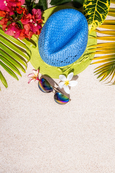 Cappello in paglia blu e verde con occhiali da sole e frangipani e buga
 - Foto, immagini