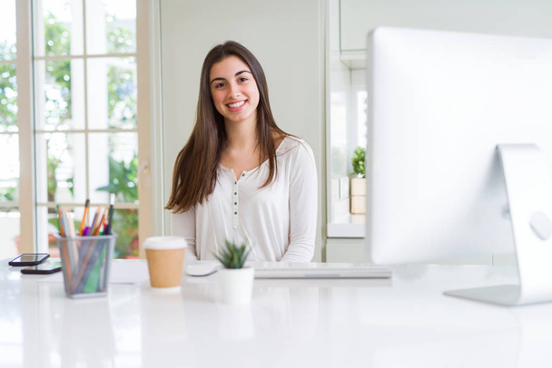 Belle jeune femme d'affaires travaillant à l'aide d'un ordinateur, souriant un
 - Photo, image