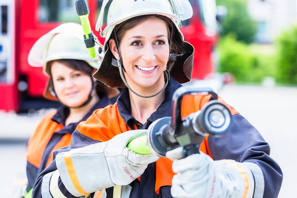 Жіночі пожежники гасять воду, щоб гасити
 - Фото, зображення