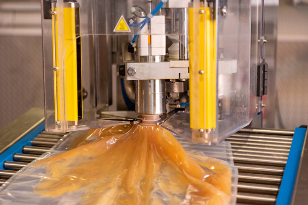  Apple direct juice after pressing. Bottling on a machine in bag - Photo, Image