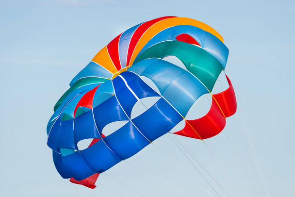 Close up shot of a colorful parachute used for parasailing pulled by a motorboat. - Photo, Image