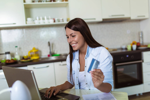 Young woman holding credit card and using laptop computer.  - Photo, Image
