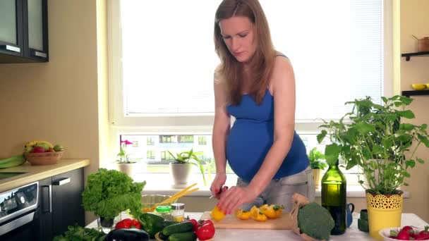 mujer embarazada en la cocina preparando ensalada
 - Metraje, vídeo