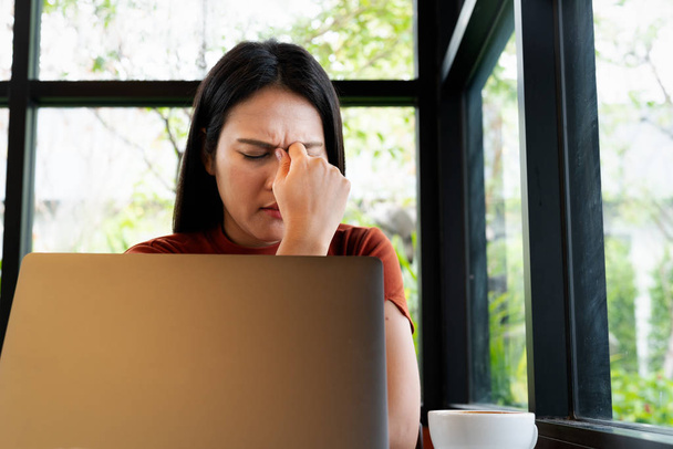 woman headache after long working on laptop. office syndrome concept - Fotó, kép