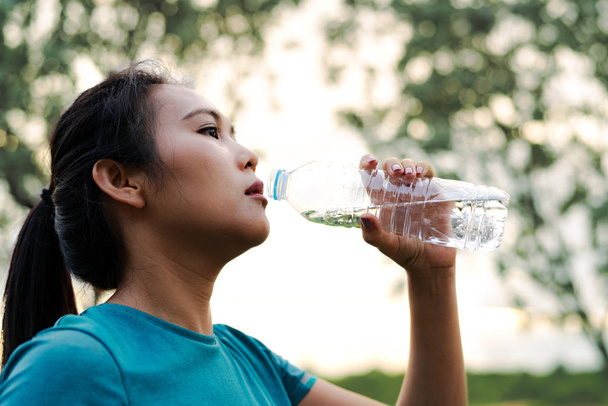 Fitness Asia vrouw drink water na het hardlopen - Foto, afbeelding