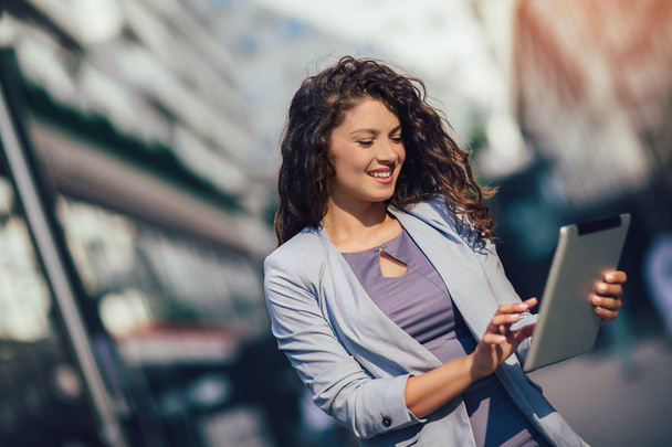 Nuori liiketoiminnan nainen käyttää digitaalista tabletti ulkona
 - Valokuva, kuva