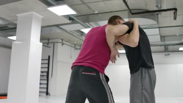 Dva zápasníci provádějí pomalý pohyb. Greco-římští zápasníci trénovat v hale s trička a kabáty. - Záběry, video