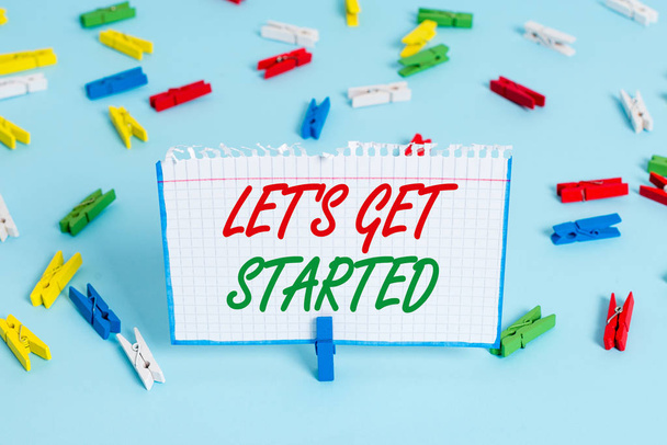 Text sign showing Let S Is Get Started. Conceptual photo to begin doing or working on something you had started Colored clothespin papers empty reminder blue floor background office pin. - Photo, Image