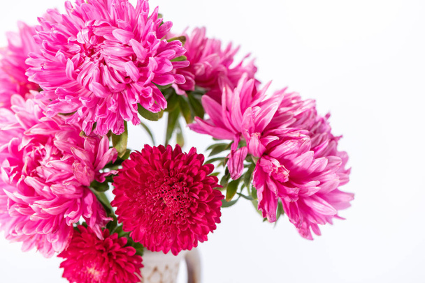 Beautiful bouquet of pink and red flowers asters in a ceramic ju - Photo, Image