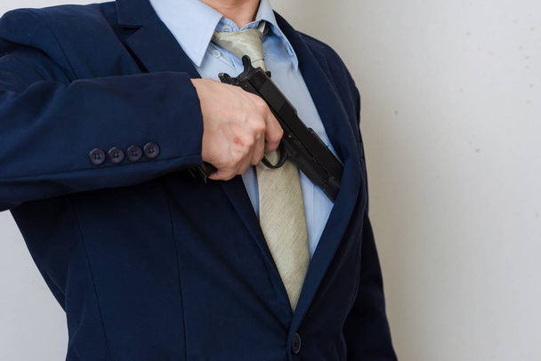 Business man in pak houden handpistool op witte achtergrond - Foto, afbeelding