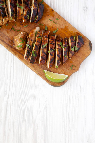 Grilled chipotle chicken breast on a rustic wooden board on a wh - Photo, Image