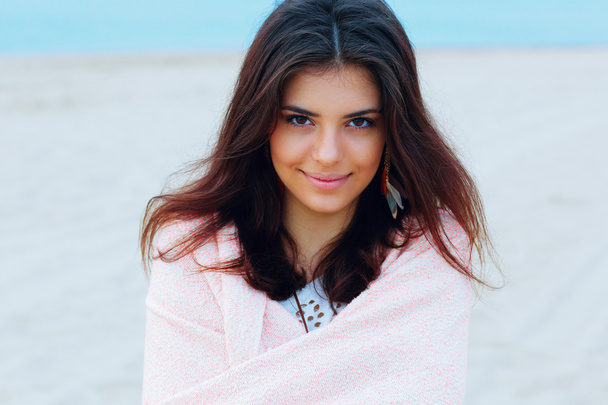 Jovem bela mulher envolveu-se com cobertor na praia
 - Foto, Imagem