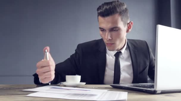 Handsome young business man working on computer laptop and drinking coffe satisfied with work results - Video