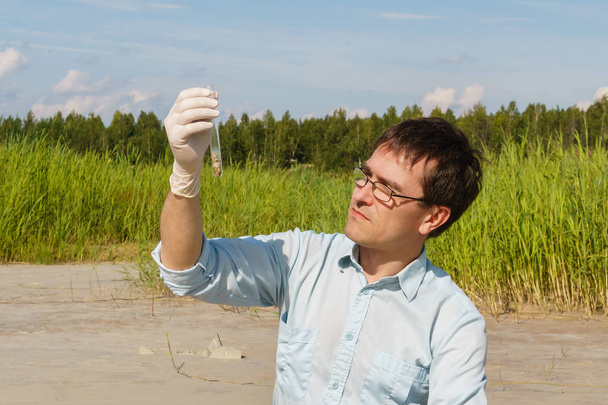 homem ecologista ou biólogo examina amostra de solo in vitro
 - Foto, Imagem