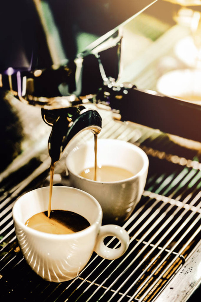 Эспрессо-машина варит кофе. Кофе наливается в бокалы.
 - Фото, изображение