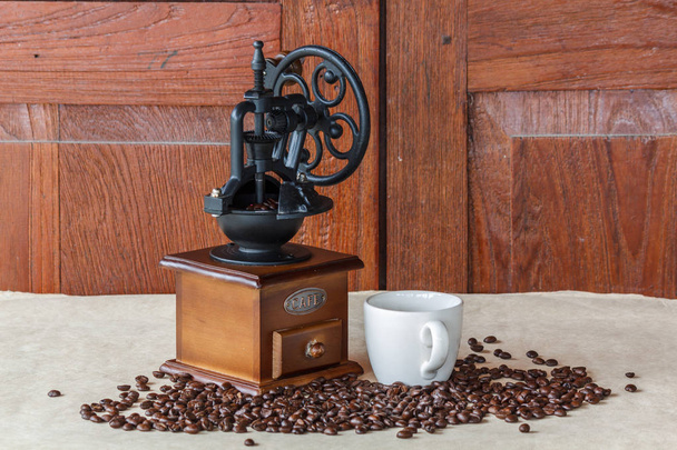 Ручная кофемолка с черными кофейными зернами
  - Фото, изображение