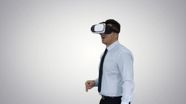 Astonished young businessman wearing VR glasses Concept of the future technology on gradient background. - Felvétel, videó