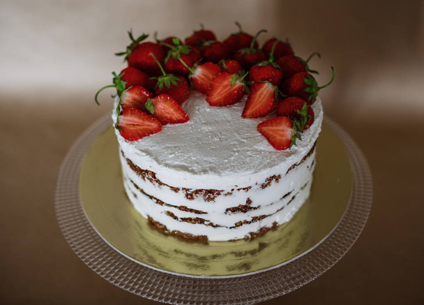 o belo bolo com morangos e nata na mesa
 - Foto, Imagem