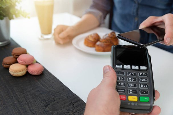 Customer making wireless or contactless payment using smartphone - Foto, Imagem