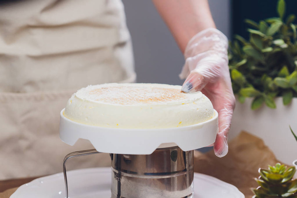 Confectioner makes a wedding cake with confectionery bag at kitchen. - Foto, Bild