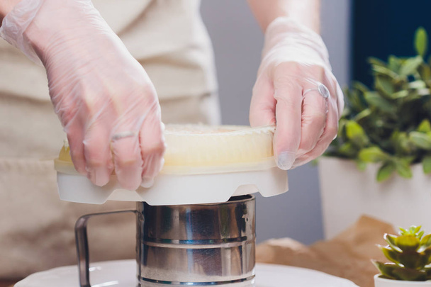 Confectioner makes a wedding cake with confectionery bag at kitchen. - Foto, Imagem