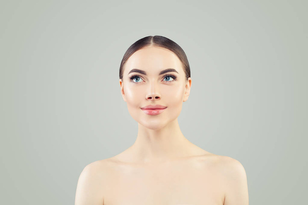 見上げる美しい女性透明な肌を持つ健康的なスパモデル - 写真・画像