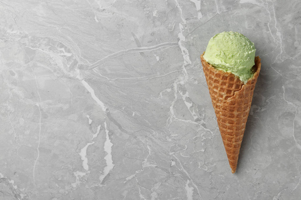 Delicious pistachio ice cream on grey marble table, top view. Space for text - Foto, Imagen