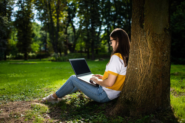 Woman Working by Laptop in Park - 写真・画像