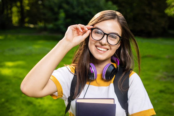 Cheerful Student Girl Adjusting Glasses - Foto, imagen