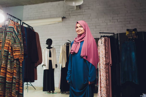Arab woman in traditional Muslim clothes buys a new dress in an Oriental store. - Foto, Imagem