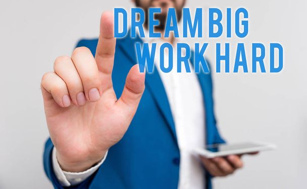 Escritura a mano conceptual que muestra Dream Big Work Hard. Texto de la foto de negocios Cree en ti mismo y sigue los sueños y metas Empresario con el dedo en la punta delante de él
. - Foto, Imagen