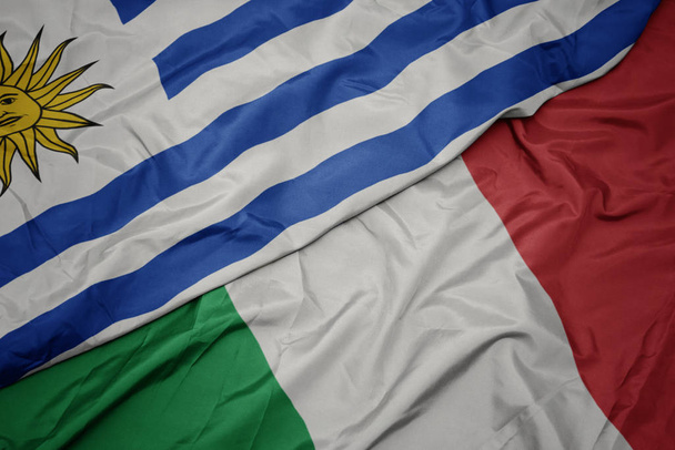 acenando bandeira colorida de itália e bandeira nacional de uruguai
. - Foto, Imagem