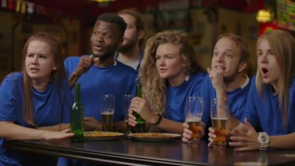 Αντίστροφη ταχύτητα αργή κίνηση ανεμιστήρες γιορτάζουν τη νίκη στο μπαρ της ομάδας τους αγκαλιές, χαρά και το ποτό με ποτήρια μπύρας - Πλάνα, βίντεο