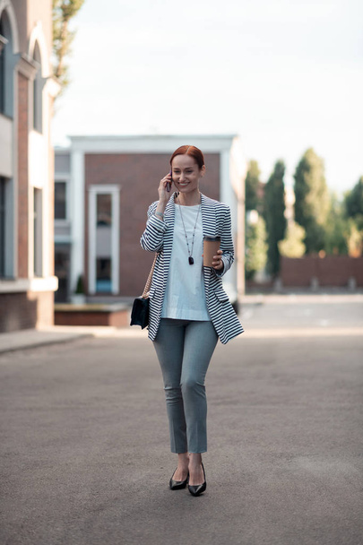 Smiling stylish young businesswoman talking on the phone - Foto, Bild