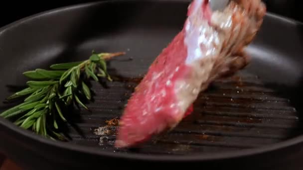 Juicy meat steak is turned on the other side for a complete frying. - Imágenes, Vídeo