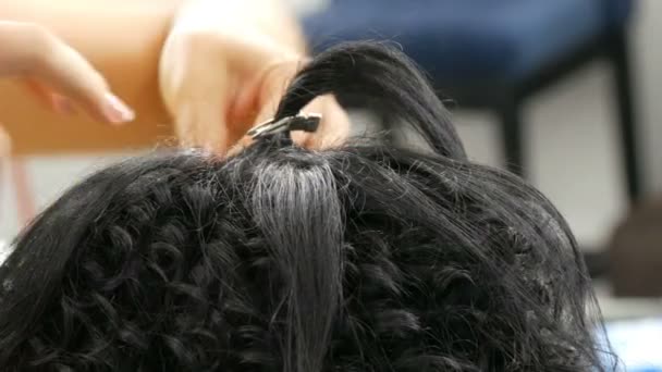 Парикмахер-стилист делает специальные вьющиеся кудряшки со специальным утюгом для завивки волос
 - Кадры, видео