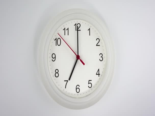 Het begin van de tijd 07,00 am of pm, close-up witte muur klok rode seconde hand minuut lopen langzaam, tijd concept. - Video