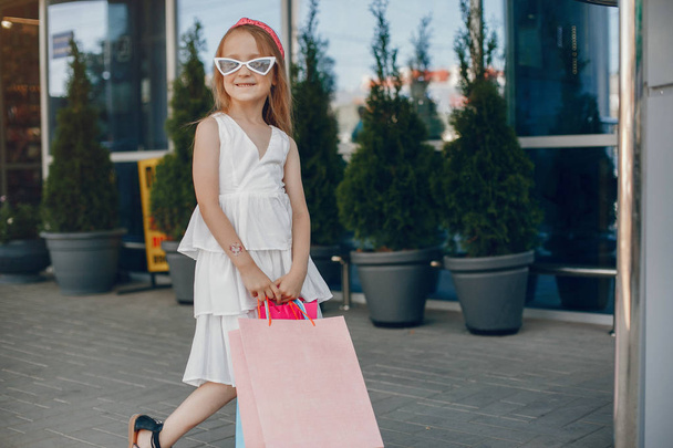 Cute little girl with shopping bag in a city - Fotó, kép