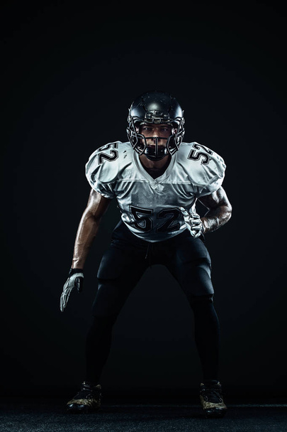 American football sportsman player in helmet on black background. Sport and motivation. Team sports. - Foto, imagen