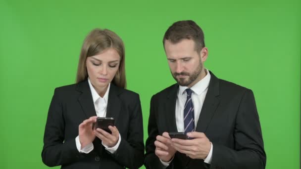 Profesionales de negocios masculinos y femeninos que usan teléfonos inteligentes contra la clave de croma
 - Metraje, vídeo