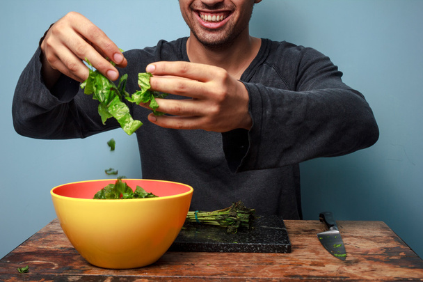 Young man is a happy salad tosser - Valokuva, kuva