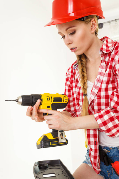 Woman using drill on ladder - Fotó, kép