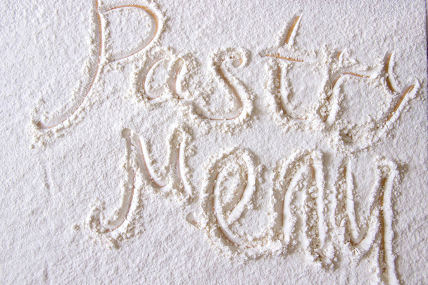 Formulierung Gebäck Menü in Mehl auf einem Holztisch geschrieben. - Foto, Bild