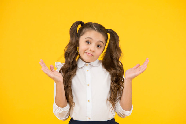 Ups. Education first. Little child making helpless gesture with hands on yellow background. Receiving compulsory school education. Education concept. A great place for education - Zdjęcie, obraz