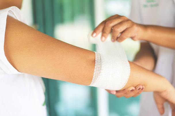 łokieć rany bandażowanie ramię przez pielęgniarkę-pierwsza pomoc kontuzji nadgarstka - Zdjęcie, obraz