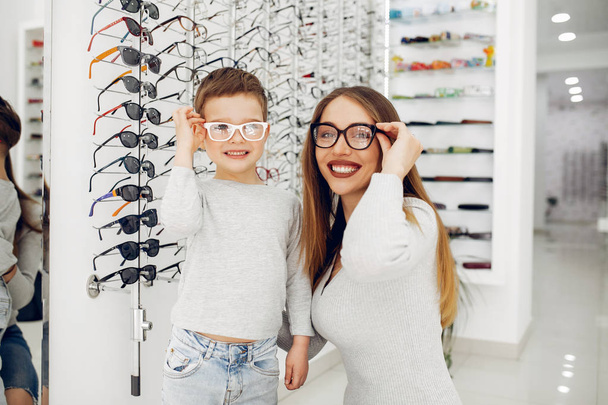 Mother with little son in the glasses store - Valokuva, kuva