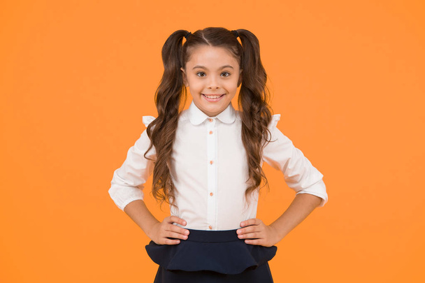 Hello school. Little schoolchild smiling on yellow background. Adorable little child with long brunette hair in formal wear. Cute little kid with innocent smile. Happy little girl back to school - Foto, afbeelding